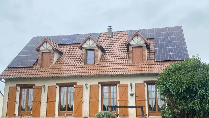 maison équipée de panneaux solaires sous un ciel gris